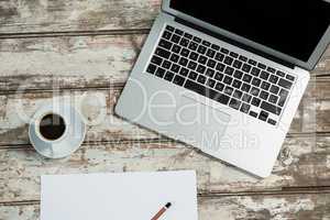 Laptop, blank sheet of paper, smartphone and coffee cup