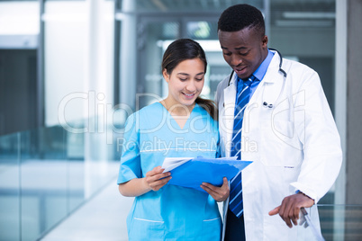 Doctor and nurse discussing over a report