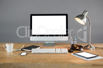 Desktop pc, digital tablet and table lamp with office accessories