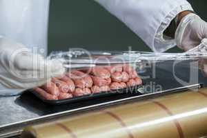 Butcher packing raw sausages