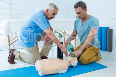 Paramedics practicing cardiopulmonary resuscitation on dummy