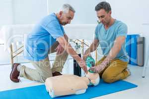 Paramedics practicing cardiopulmonary resuscitation on dummy