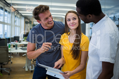 Graphic designers discussing over digital tablet
