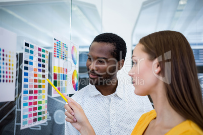 Graphic designers looking at color chart