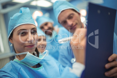 Team of surgeons having discussion over clipboard