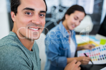 Smiling graphic designers at desk