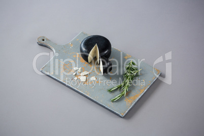 Gouda cheese with rosemary leaves on chopping board