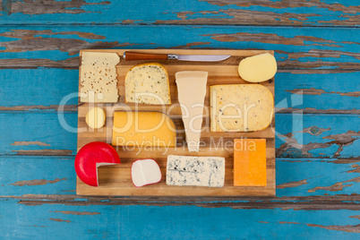 Cheese with knife on chopping board