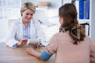 Female doctor checking blood pressure of a patient