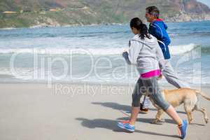 Couple jogging with pet dog