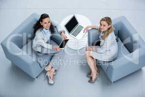 Portrait of businesswomen with laptop and digital tablet