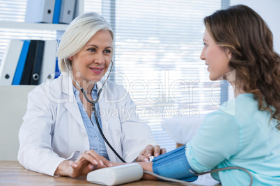 Female doctor checking blood pressure of a patient