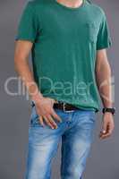 Man in green t-shirt posing against grey background