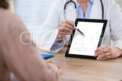 Doctor discussing with patient over digital tablet at the hospital