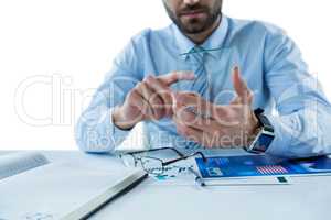 Businessman sitting at table touching a glass sheet
