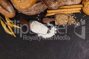 Various bread loaves with flour and wheat grains