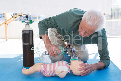 Paramedic practicing resuscitation on dummy