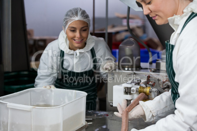 Butchers processing sausages