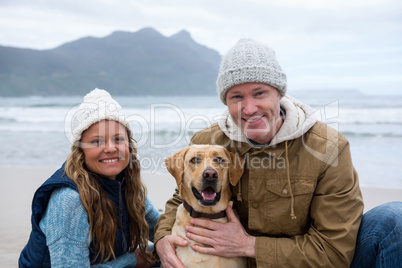 Smiling couple with pet dog at the beach