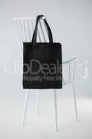 Black bag hanging on a white chair