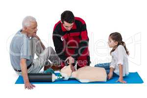 Paramedic training cardiopulmonary resuscitation to senior man and girl