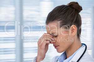 Tired female doctor having headache