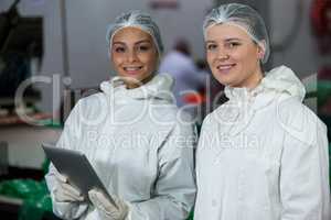 Female butchers standing at meat factory