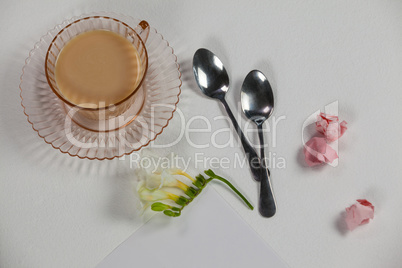 Cup of tea, spoons, blank page, paper balls and flower