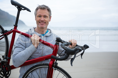 Man carrying bicycle on beach Man carrying bicycle on beach