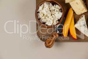 Different cheese and knife on wooden board