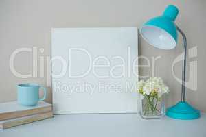 Picture frame, coffee cup with table lamp and flower vase