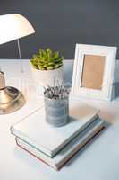 Table lamp, picture frame and books on table