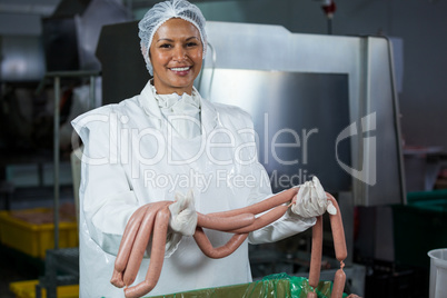 Female butcher holding sausages