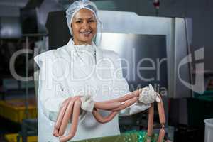 Female butcher holding sausages