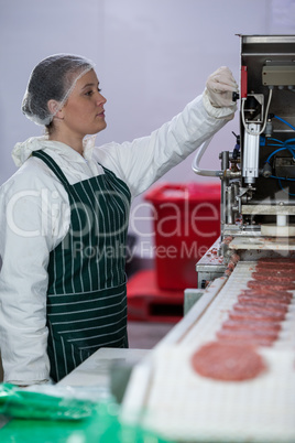 Female butcher processing hamburger patty makers