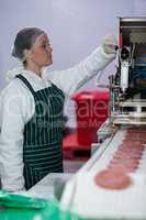 Female butcher processing hamburger patty makers