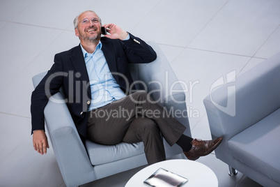 Businessman sitting on a chair and talking on mobile phone