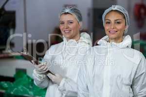Female butchers holding clipboard