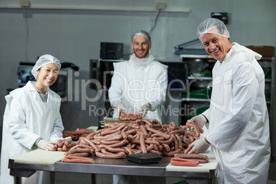 Butchers processing sausages