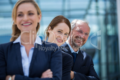 Smiling businesspeople standing with hands crossed