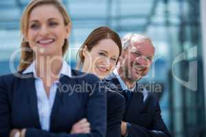 Smiling businesspeople standing with hands crossed