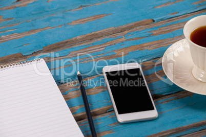 Notepad, pencil, smartphone and cup of tea