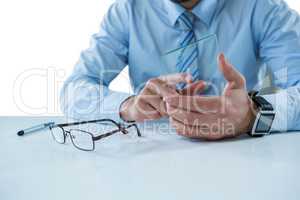 Businessman sitting at table touching a glass sheet