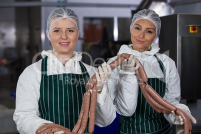 Female butchers processing sausages