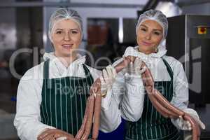 Female butchers processing sausages