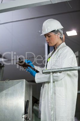 Technician examining meat processing machine