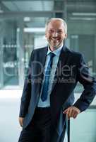 Smiling businessman standing in office lobby