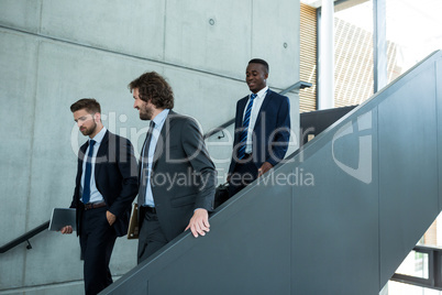 Group of businessmen climbing down stairs