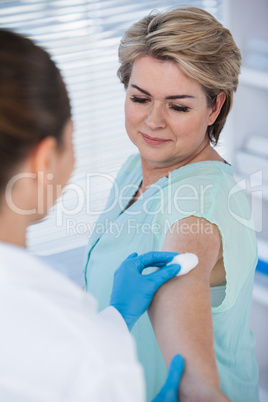 Doctor rubbing patient arm from cotton before injection