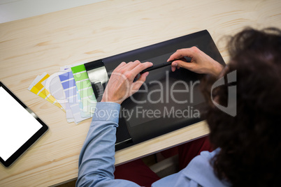 Graphic designer with a graphic tablet sitting at his desk
